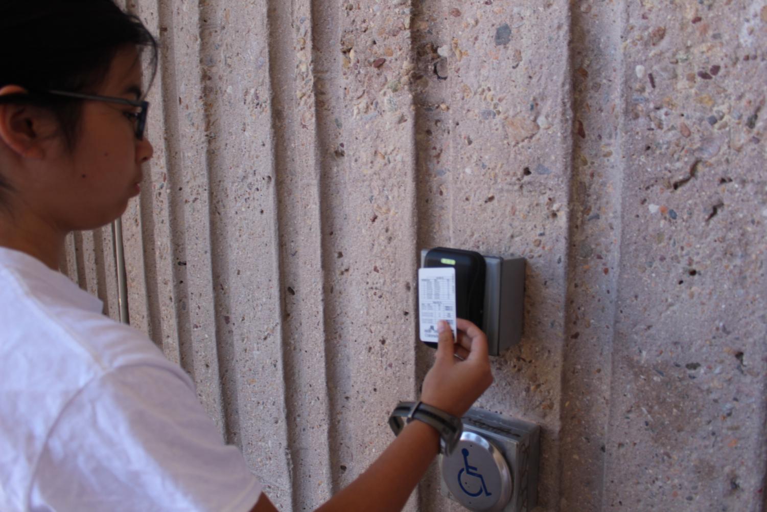 Phoebe Wu, freshman, scans her ID card at the bottom of the school to get inside during seventh period.
