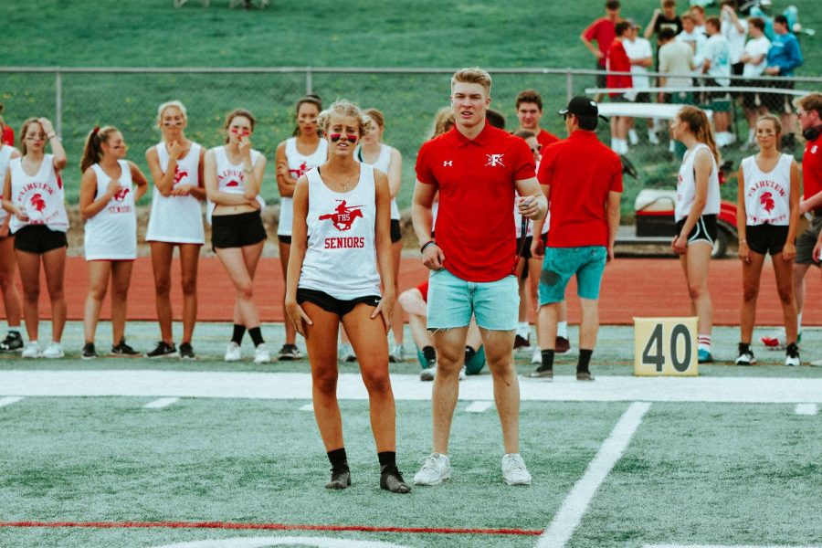 Seniors Matt Greenwald and Emma Carter look out to the field during a timeout in the first half of the powderpuff football game. 