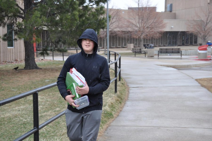 Sophomore Jasper Bloom carries his school supplies from Fairview early on Friday morning.